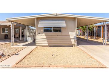 Charming single-story home with a covered carport and front gravel yard at 11411 N 91St Ave # 28, Peoria, AZ 85345