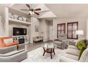 Inviting living room featuring vaulted ceilings, stylish furnishings, and a cozy fireplace at 3301 S Goldfield Rd # 6050, Apache Junction, AZ 85119