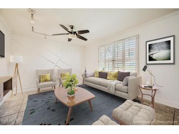 Bright living room with a ceiling fan, modern furnishings, large windows, and an accent wall at 5166 N 83Rd St, Scottsdale, AZ 85250