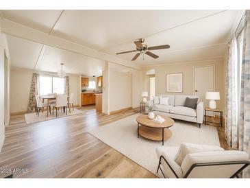 Bright living room featuring hardwood floors, a ceiling fan, and an open-concept layout at 10951 N 91St Ave # 16, Peoria, AZ 85345