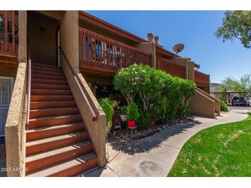 Charming condo exterior featuring wood railings, desert landscaping, and a well-maintained walkway at 14203 N 19Th Ave # 2036, Phoenix, AZ 85023