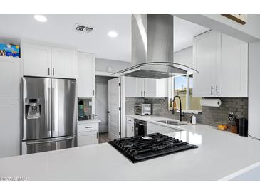 Bright kitchen boasts sleek countertops, stainless steel appliances, and updated fixtures for a modern feel at 1615 E Roma Ave, Phoenix, AZ 85016