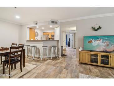 Open-concept living room with breakfast bar and wood-look flooring, ready for entertaining and comfortable living at 2025 E Campbell Ave # 107, Phoenix, AZ 85016