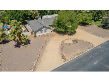 Aerial view of a single-Gathering home featuring mature trees and a gravel yard at 3964 S Turquoise Dr, Buckeye, AZ 85326