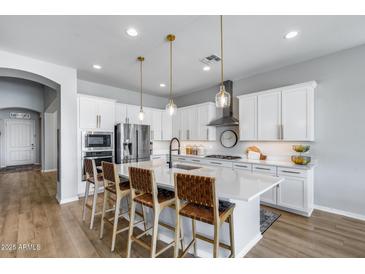 Beautiful kitchen with white cabinetry, stainless steel appliances, and a large center island at 41650 W Barcelona Dr, Maricopa, AZ 85138