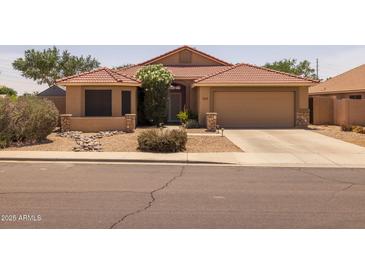 Charming single-story home with a well-manicured, low-maintenance desert landscape and tile roof at 7701 E Portobello Ave, Mesa, AZ 85212