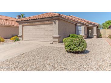 Charming single-story home featuring a two-car garage, desert landscaping, and a classic tile roof at 17434 N 46Th Pl, Phoenix, AZ 85032