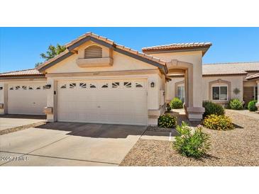 Beige one-story home featuring a well maintained front yard and a two car garage at 10347 W Mohawk Ln, Peoria, AZ 85382