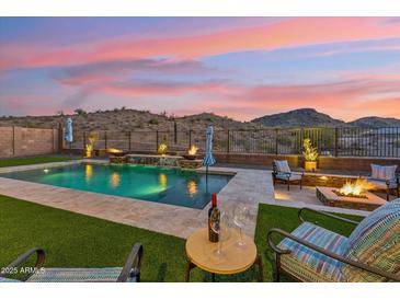 Inviting backyard with pool, fire pit, and desert views, perfect for outdoor entertaining at 16417 W Fawn Dr, Goodyear, AZ 85338