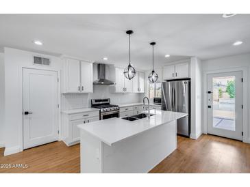Renovated kitchen featuring a large island, stainless steel appliances, and pendant lighting at 2336 E Flower St, Phoenix, AZ 85016