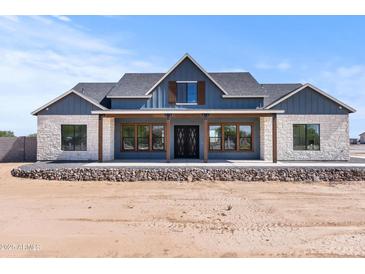 Charming single-story home featuring stone accents, a symmetrical design and a welcoming front porch at 300 S Charleston Ct, Casa Grande, AZ 85194