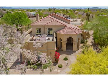 Stunning exterior view of a tan home with a red tiled roof and lush desert landscaping at 4727 E Rancho Caliente Dr, Cave Creek, AZ 85331