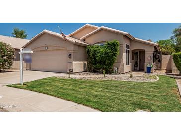 Charming single-story home featuring a well-maintained lawn and two-car garage at 51 N Rush St, Chandler, AZ 85226