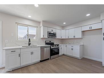 Bright kitchen features white cabinets, stainless steel appliances, and marble countertops at 733 W El Prado Rd, Chandler, AZ 85225