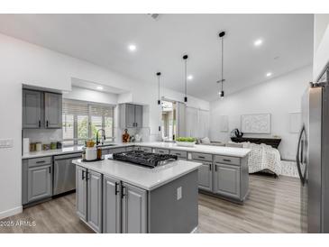 Modern kitchen featuring gray cabinets, quartz countertops, a gas cooktop, and stainless steel appliances at 8449 W Rockwood Dr, Peoria, AZ 85382