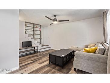 Comfortable living room with ceiling fan, unique staircase with decorative tile, and stylish wood flooring at 8538 E Portland St, Scottsdale, AZ 85257