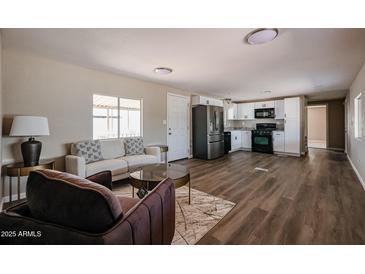 Bright living room featuring modern furniture, wood-look floors, and a seamless flow into the kitchen at 8600 E Broadway Rd # 53, Mesa, AZ 85208
