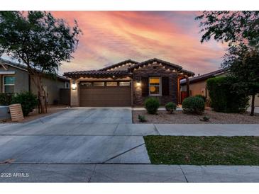Charming single-Gathering home boasting a two-car garage and stone veneer, complemented by a well-manicured lawn at 9831 E Tupelo Ave, Mesa, AZ 85212