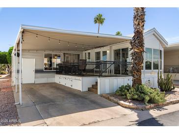 Charming home exterior featuring a covered patio, carport, and mature desert landscaping at 111 S Greenfield Rd # 190, Mesa, AZ 85206