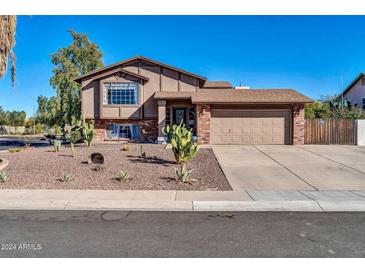 Charming two-story home featuring a brick facade, desert landscaping and a two-car garage at 13051 N 75Th Dr, Peoria, AZ 85381