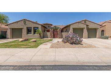 Charming home featuring desert landscaping, a gated entry, and dual two-car garages at 14538 W Sheridan St, Goodyear, AZ 85395