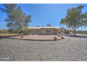 Charming ranch home features metal roof, gravel yard, and covered parking at 2627 W Buckskin Trl, New River, AZ 85087