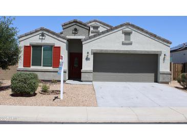 Charming single-Gathering home with a neutral-toned exterior, gravel landscaping, and a two-car garage at 30918 W Mulberry W Dr, Buckeye, AZ 85396