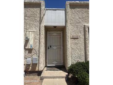 Home's entry features a secure metal screen door, offering both protection and a welcoming appeal to guests at 8110 N 31St Dr, Phoenix, AZ 85051