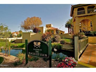 Beautiful Racquet Club sign near lush landscaping and inviting water feature on a sunny day at 9707 E Mountain View Rd # 1408, Scottsdale, AZ 85258