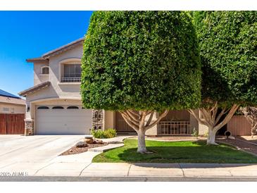 Charming two-story home boasts a landscaped yard and attached two-car garage at 14604 W Banff Ln, Surprise, AZ 85379
