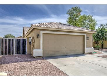Inviting single-Gathering home featuring a neutral color palette, desert landscaping, and an attached two car garage at 15067 W Taylor St, Goodyear, AZ 85338