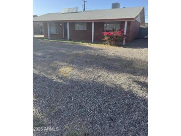 Charming single-story brick home with a gravel front yard and covered porch, located in a quiet neighborhood at 3226 W Maryland Ave, Phoenix, AZ 85017