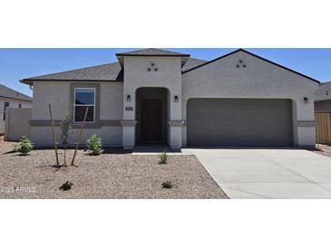 Charming single-story home featuring a stucco facade, arched entryway, and well-manicured desert landscaping at 5827 E Axle Ln, San Tan Valley, AZ 85140