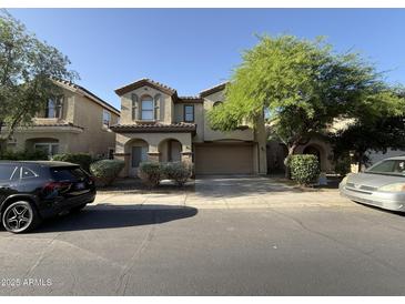 Inviting two-story home showcasing well-manicured landscaping, arched entryway, and a two-car garage at 6341 W Valencia Dr, Laveen, AZ 85339