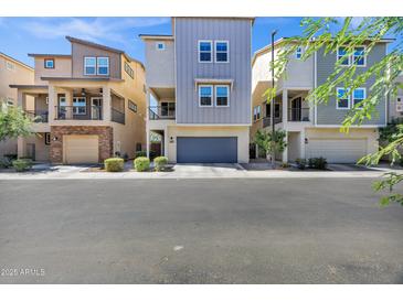 Modern townhomes featuring two-story designs with attached garages and landscaped front yards at 751 W Flintlock Way, Chandler, AZ 85286