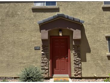 Inviting front door with stone accents and covered entryway, offering a warm welcome to this charming home at 1350 S Greenfield Rd # 2205, Mesa, AZ 85206