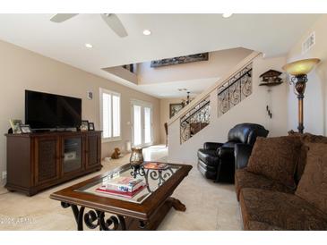 Cozy living room featuring comfortable seating, an entertainment center, and a staircase with ornate railing at 15550 N Frank Lloyd Wright N Blvd # 1040, Scottsdale, AZ 85260