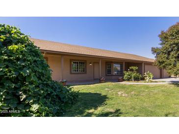 Charming single-story home features a well-manicured lawn and inviting front porch at 19006 E Karsten Dr, Queen Creek, AZ 85142