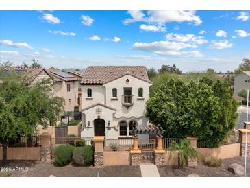 Stunning two-story home featuring a Spanish-style tile roof and a charming gated front yard at 2004 E Heartwood Ln, Phoenix, AZ 85022