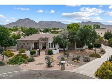 Stunning home featuring a desert landscape, tile roof, stone accents, and picturesque mountain views at 21205 E Excelsior Ave, Queen Creek, AZ 85142