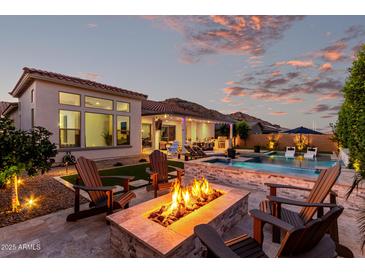 Outdoor entertaining space featuring a pool, built-in grill, and a cozy fire pit with seating at 21449 W Mariposa St, Buckeye, AZ 85396