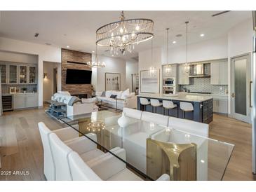 Open-concept living area with modern decor, brick fireplace, and glass dining table at 3626 N Mohave Way, Scottsdale, AZ 85251
