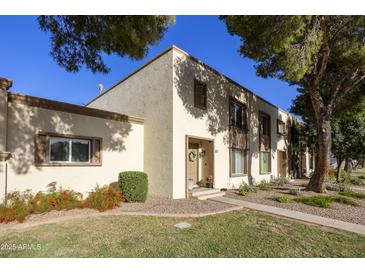 Charming townhome with a well-maintained lawn and colorful flower beds, complemented by mature shade trees at 5111 N 83Rd St, Scottsdale, AZ 85250