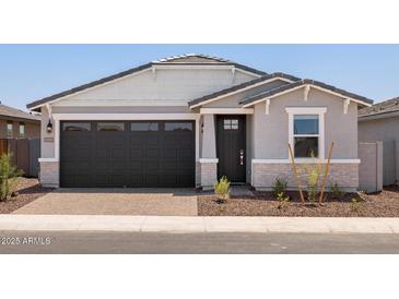 Charming single-story home featuring a dark garage door and decorative stone accents at 5549 S 246Th Ave, Buckeye, AZ 85326