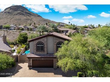 Beautiful two-story home featuring stone accents, arched windows, desert landscaping, and tile roof at 1922 E Everett Dr, Phoenix, AZ 85022