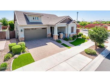 Beautiful single-Gathering home featuring stone accents, a well-manicured lawn, and a paver driveway and walkway at 2611 S Quaintance St, Gilbert, AZ 85295