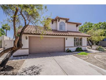 Charming two-story home with a tan garage door, tile roof, and well-maintained landscaping at 4627 E Mcneil St, Phoenix, AZ 85044