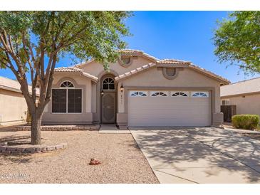 Charming single-story home with a two-car garage and well-maintained desert landscaping in front at 4911 E Holmes Ave, Mesa, AZ 85206