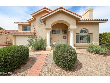 Charming two-story home featuring a tile roof, arched entry, and manicured front yard at 7110 N 28Th Dr, Phoenix, AZ 85051