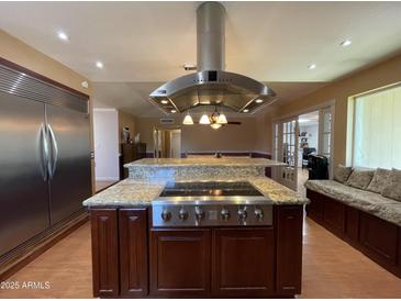 Gourmet kitchen featuring a central island with a cooktop and granite countertops at 9221 N 48Th Dr, Glendale, AZ 85302